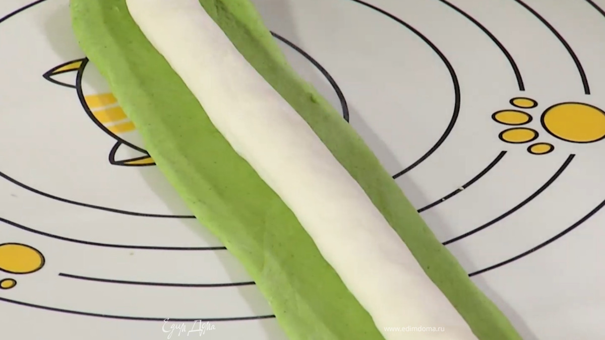 Сформировать из белого теста длинную колбаску. Зеленое тесто раскатать в длинную полоску, смочить ее водой по всей длине, выложить в центр белую колбаску и защипать зеленое тесто так, чтобы белое оказалось внутри.