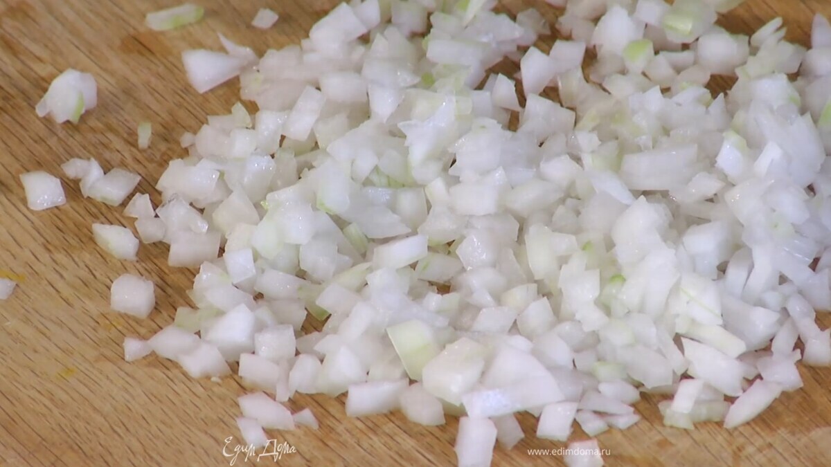 Приготовить начинку: лук почистить, мелко нарезать и обжарить на разогретом в сковороде оливковом масле.