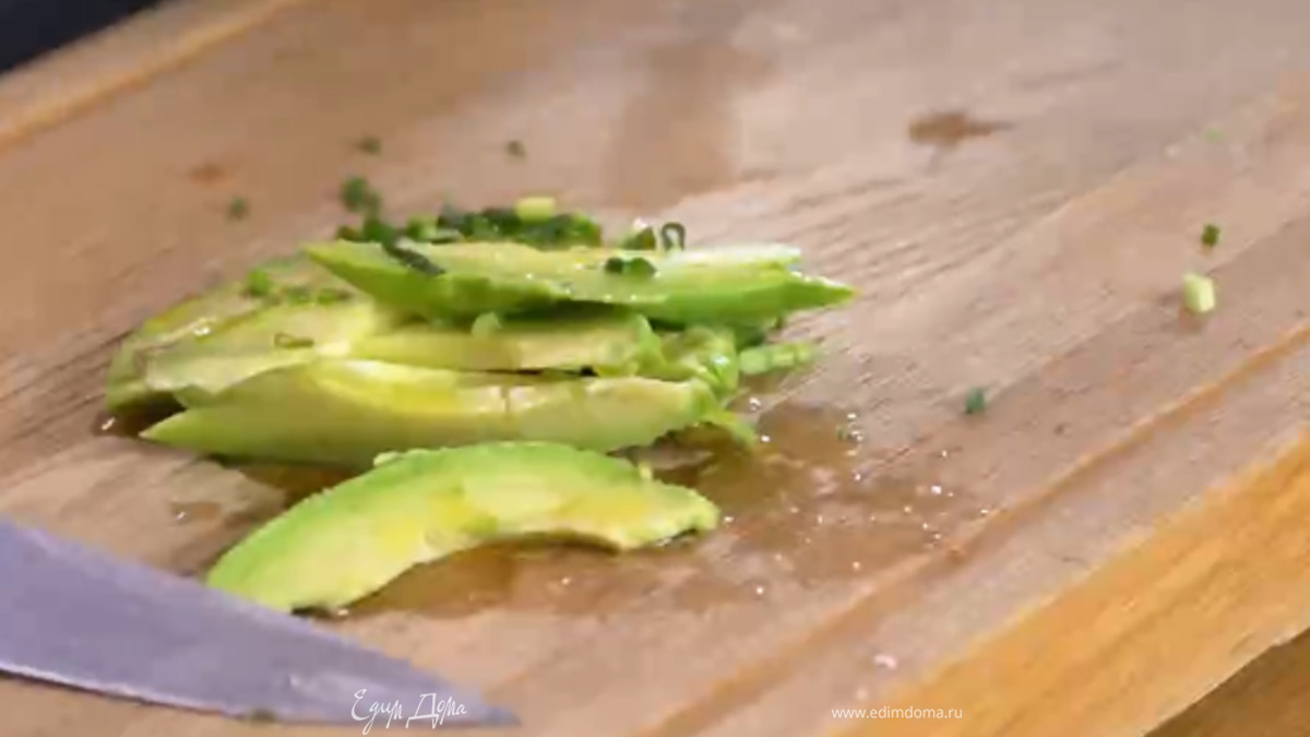 Авокадо почистить и, удалив косточку, нарезать кусочками, полить оливковым маслом Extra Virgin и выжатым из лимона соком, добавить зеленый лук, все посолить и перемешать.