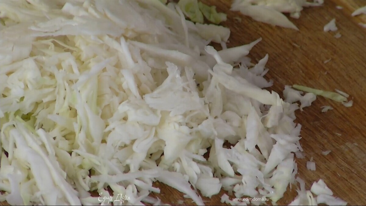 Капусту нашинковать очень тонко, выложить в глубокую миску, посолить и помять руками.