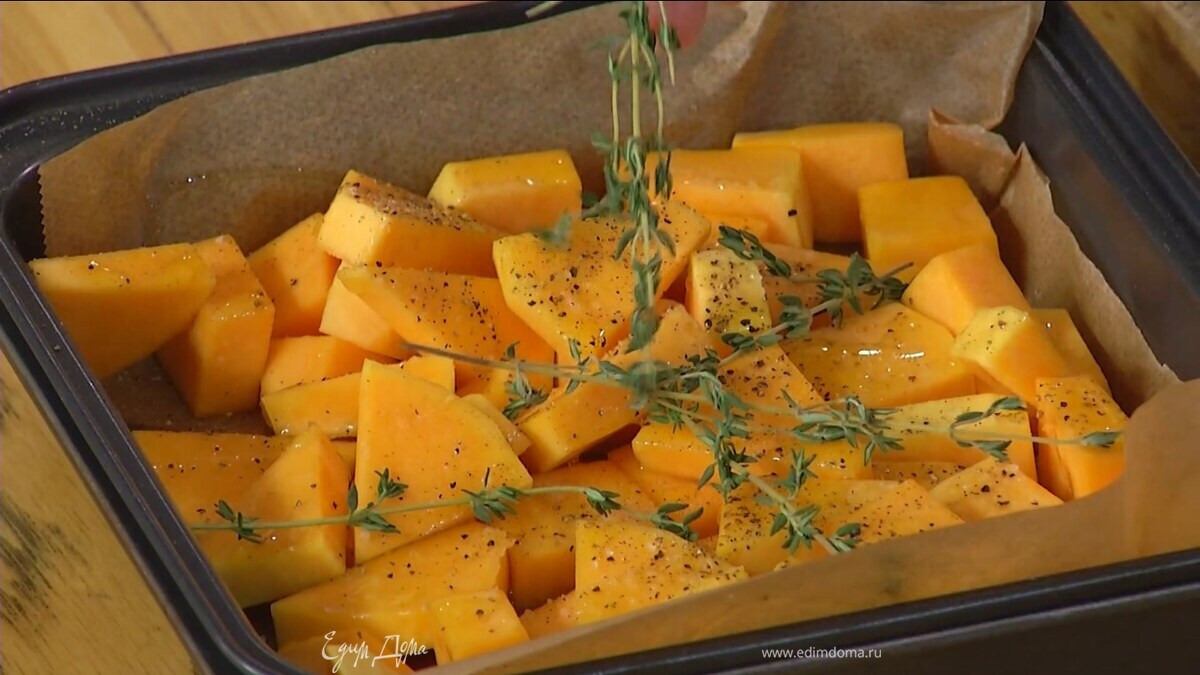 Тыкву очистить и нарезать кубиками, выложить на небольшой противень, выстеленный бумагой для выпечки, сбрызнуть оливковым маслом, посолить, поперчить, сверху разложить веточки тимьяна.