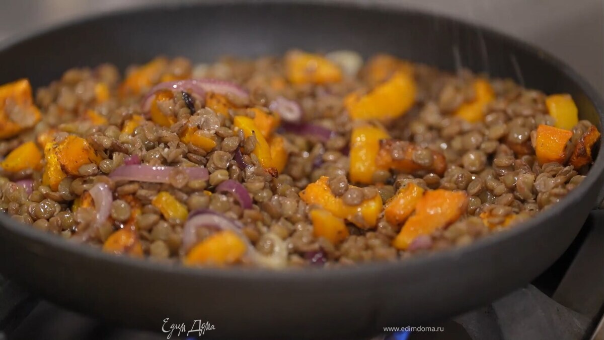 Запеченную тыкву, удалив веточки тимьяна, выложить в сковороду с луком и чесноком, добавить чечевицу, все посолить и прогреть.