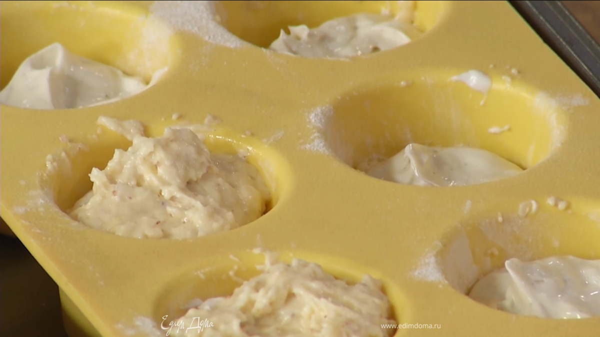 Силиконовые формы для выпечки смазать сливочным маслом, обсыпать оставшейся мукой и на треть заполнить тестом, затем разложить сливочную начинку и покрыть все оставшимся тестом.