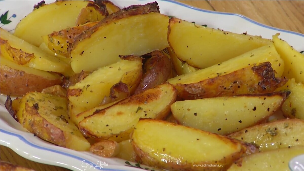 Запекать в разогретой духовке 10–15 минут, затем понизить температуру до 200℃, сбрызнуть картофель оставшимся оливковым маслом и запекать до золотистого цвета.