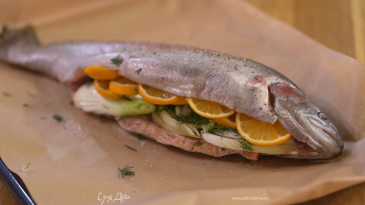 Выстелить противень двойным слоем бумаги для выпечки, выложить форель, посолить и поперчить со всех сторон, поместить в брюшко лимон, фенхель, зелень укропа и фенхеля, веточки петрушки и тимьяна, затем сбрызнуть рыбу оливковым маслом, накрыть еще одним слоем бумаги для выпечки и скрепить края так, чтобы получился сверток.
