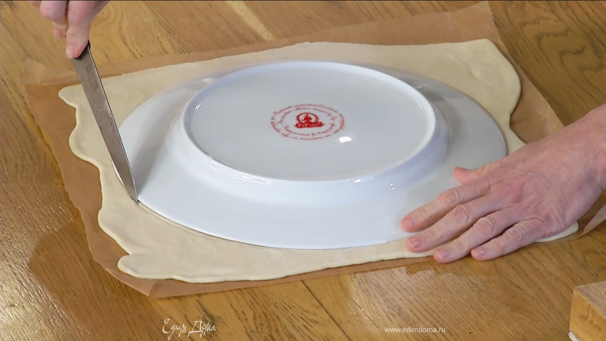 Тесто предварительно разморозить, затем раскатать на бумаге для выпечки и вырезать из него круг.