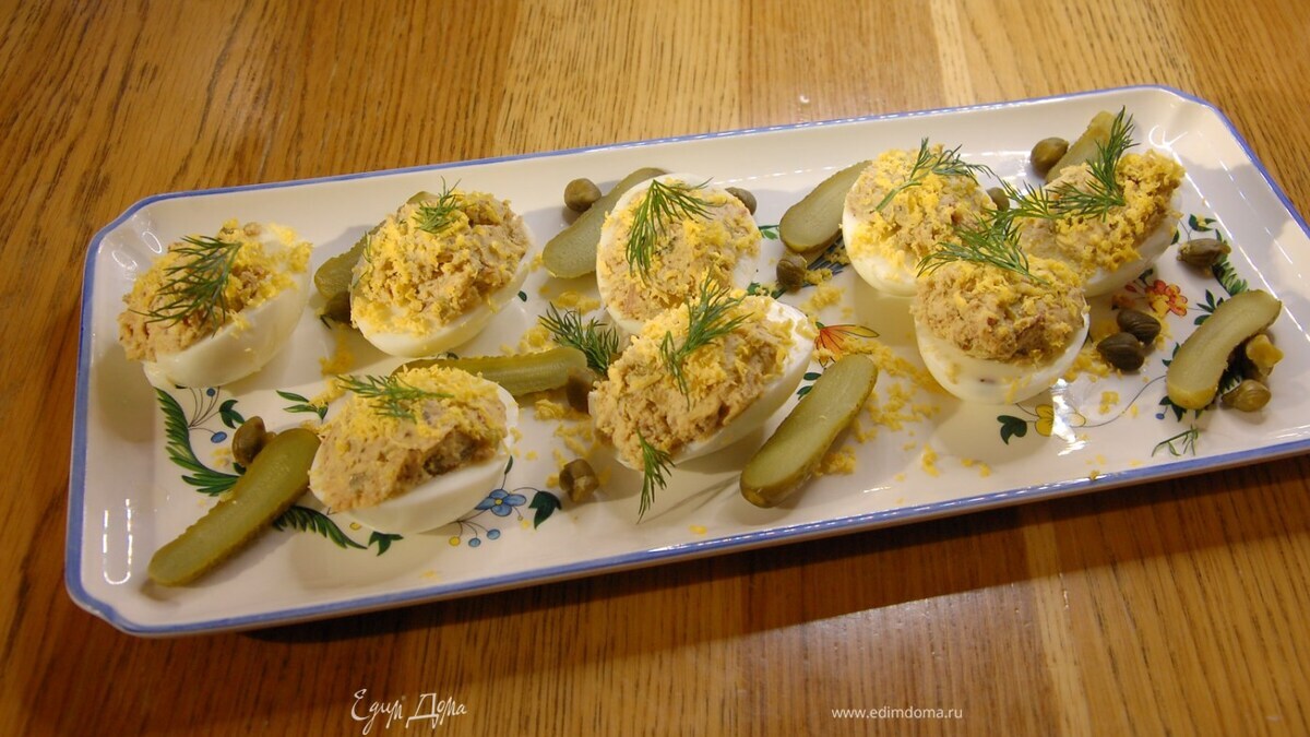 Оставшийся желток натереть на мелкой терке, посыпать фаршированные яйца и украсить укропом.