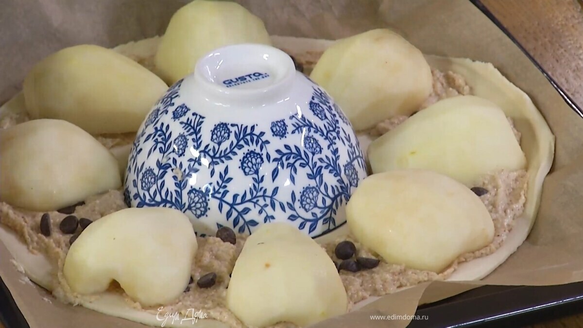 Тесто вокруг пиалы смазать ореховым кремом, слегка посолить, посыпать шоколадными пуговицами, затем разложить половинки груш срезами вниз.