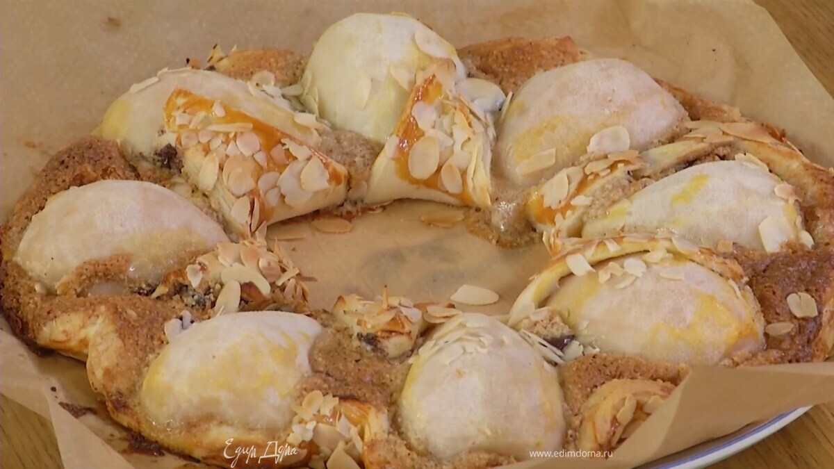 Тесто по краям завернуть бортиком и смазать все желтком, перемешанным со щепоткой соли, посыпать все миндальными лепестками и выпекать в разогретой духовке 25–30 минут.