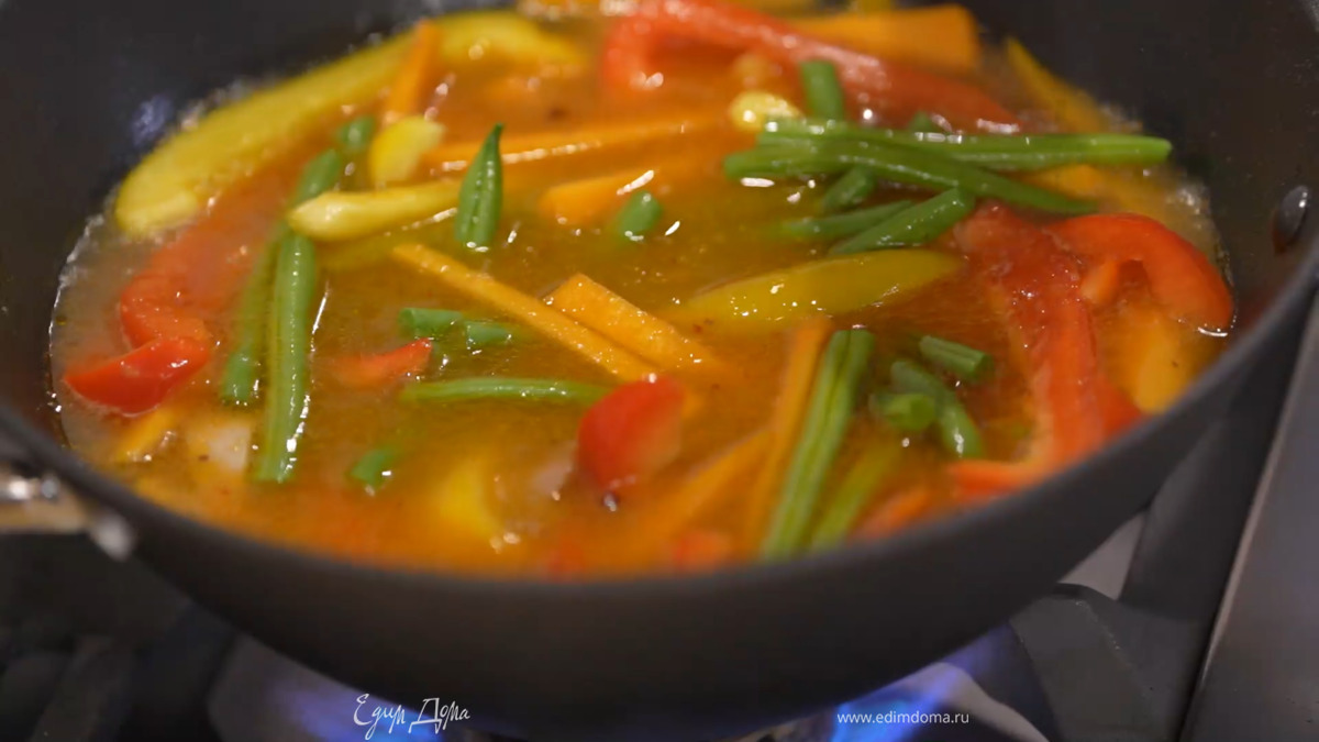 В сотейник с мясом выложить тыкву и пасту карри, посыпать сычуаньским перцем и чили, все перемешать, затем добавить сладкий перец, стручковую фасоль и залить горячим бульоном так, чтобы овощи были покрыты.