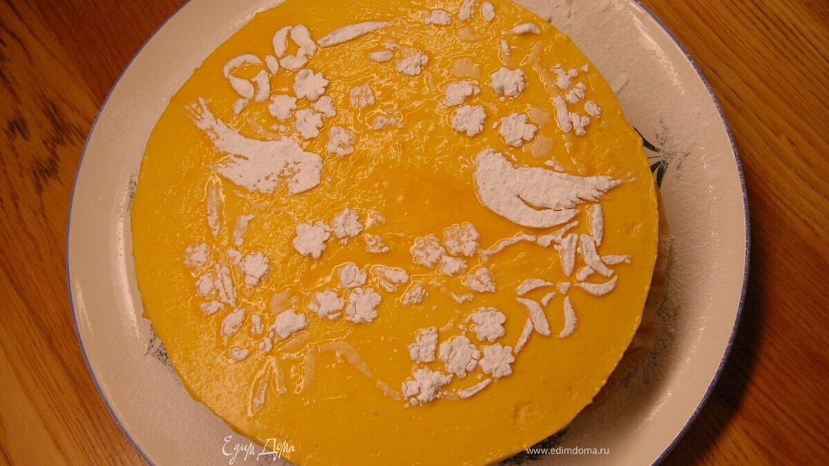 На остывший десерт наложить бумажный трафарет с рисунками и посыпать все сахарной пудрой.