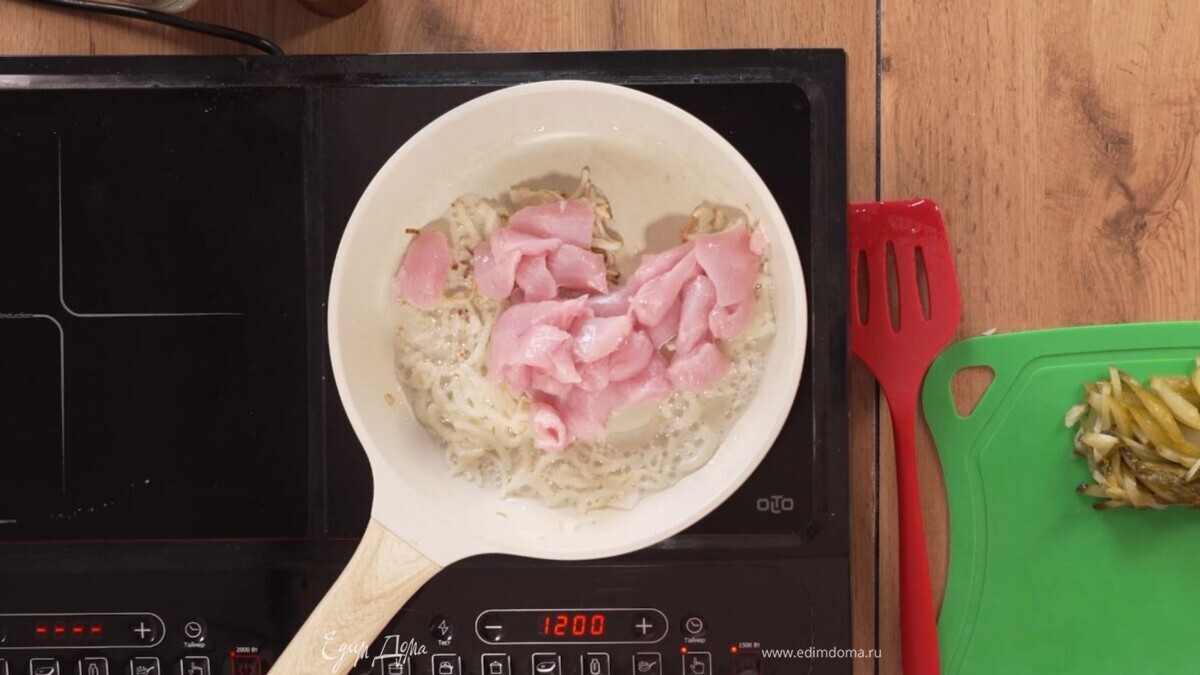 Выложите к луку индейку. Не перегружайте сковороду — иначе будет не жарка, а тушение. Когда появился коричневый оттенок, добавьте огурцы, нарезанные соломкой. Не жалейте огурцов. От их кислоты мясо станет нежным. Тушите 5 минут.<br />
 