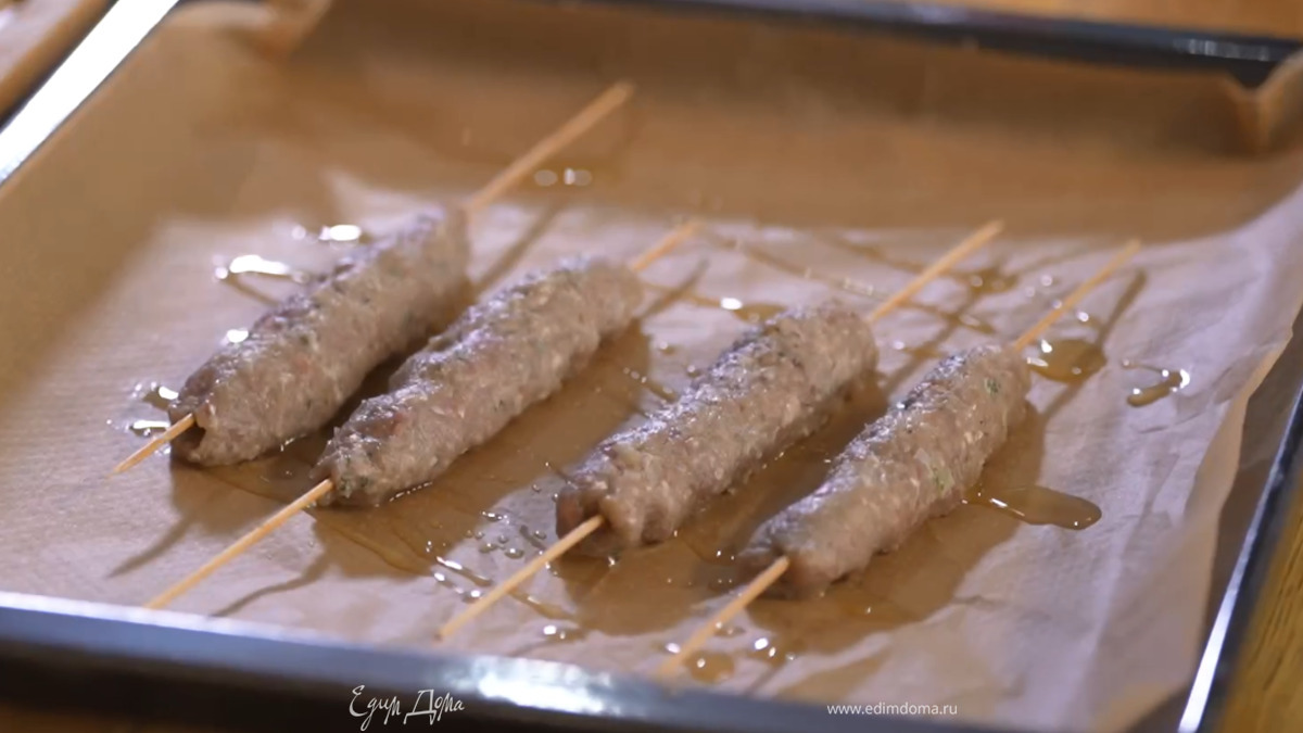 Противень выстелить бумагой для выпечки, смазать ее оливковым маслом, выложить колбаски, сбрызнуть сверху оставшимся маслом и отправить в разогретую духовку на 7–10 минут.