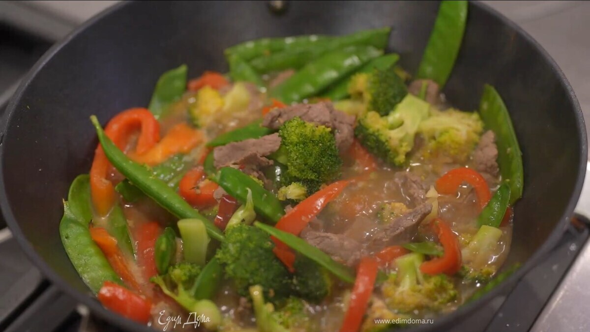 Выложить к овощам мясо без маринада, перемешать и обжарить, затем добавить стручки гороха и тоже слегка обжарить, всыпать крахмал, влить горячий бульон и довести все до готовности.