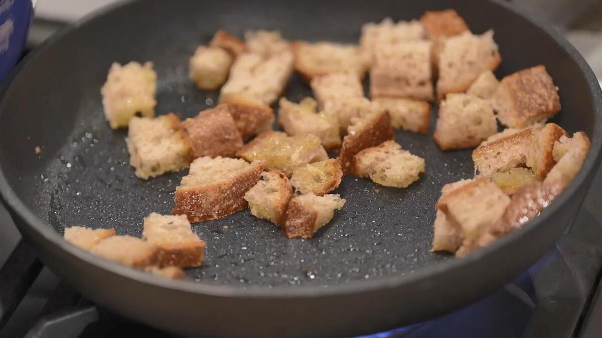 Хлеб нарезать небольшими кусочками и обжарить в сковороде на разогретом оливковом масле.