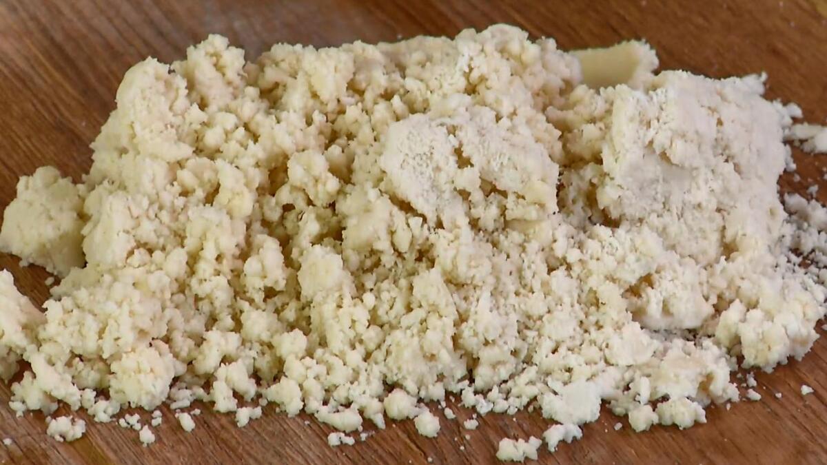 Предварительно охлажденное сливочное масло нарезать кубиками, выложить в чашу комбайна, всыпать муку с солью и взбить все в крошку, затем влить 2&ndash;3 ст. ложки ледяной воды и взбить все еще немного.