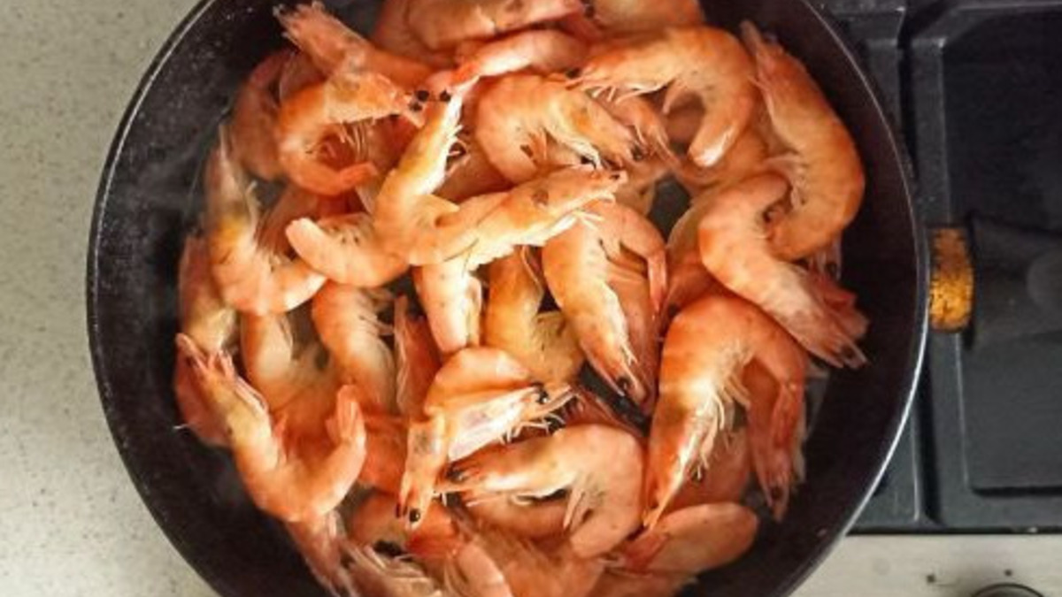 Разогрейте масло на сковороде и обжарьте измельчённый чеснок 30–40 секунд. Добавьте креветки, посолите и поперчите.