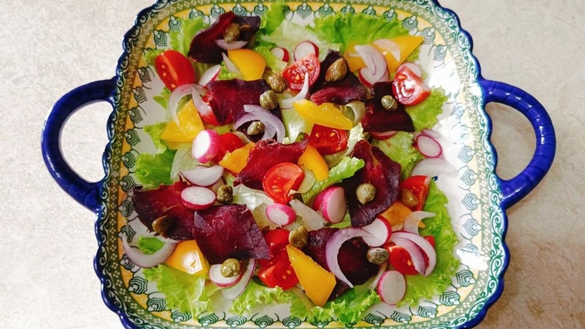 Сыровяленое говяжье мясо нарезать тонкими слайсами. Посыпать салат каперсами.