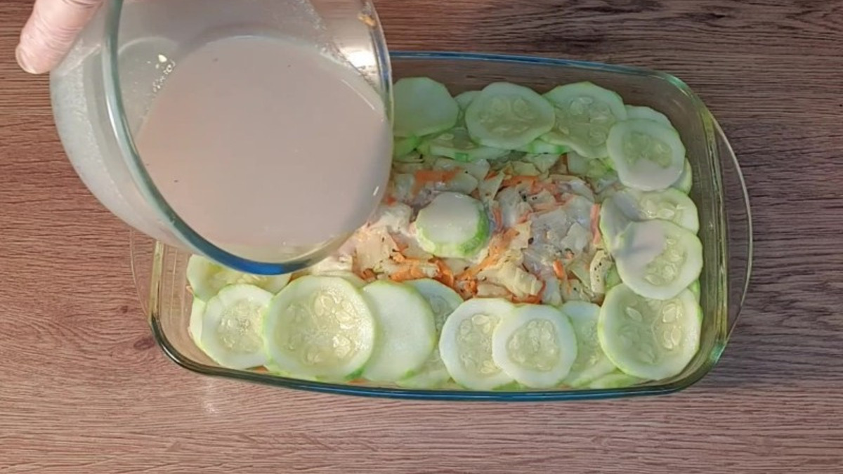 Раскладываем дольки кабачка и выливаем оставшийся соус.