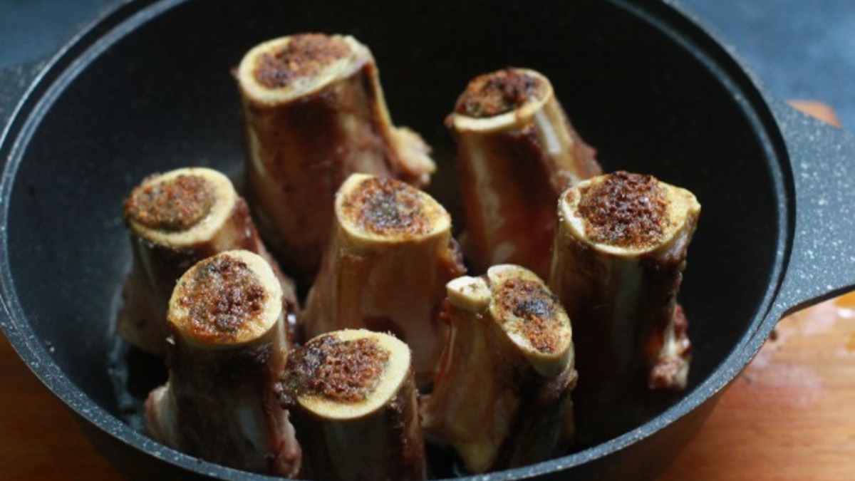Кости вымыть, поставить в посуду для запекания (если кости не могут стоять устойчиво, помять кусок фольги, положить его на дно формы и сбалансировать спилы). В мисочке смешать немного оливкового масла, соль, щепотку чили, свежесмолотый черный перец, сухой чеснок (свежий нельзя, он будет гореть) и любые ваши специи. Выложить смесь поверх спилов костей, поставить в разогретую до 205 С духовку на 25 минут.