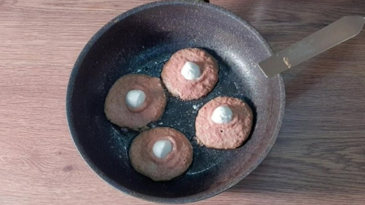 Смазываем сковороду растительным маслом и раскладываем печеночное тесто. Сразу же кладем начинку и закрываем тестом.