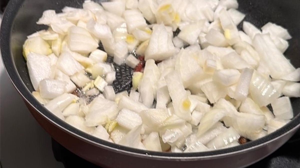 2. Приготовить мясную начинку Лук мелко нарезать. Разогреть растительное масло на сковороде и обжарить лук до мягкости. Добавить мясной фарш и обжаривать, разбивая его лопаткой, пока мясо не изменит цвет и слегка не подрумянится. Добавить часть нарезанных помидоров, соль, перец и итальянские травы. Тушить еще 10-15 минут, чтобы получился сочный мясной соус.