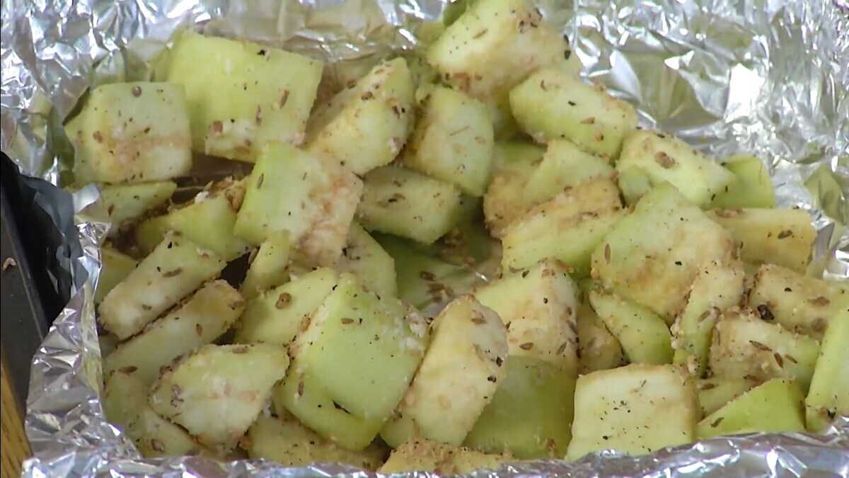 Кубики баклажана посыпать мукой и измельченными специями, перемешать и выложить в выстеленную фольгой форму для запекания, сбрызнуть оливковым маслом и запекать в разогретой духовке до готовности.