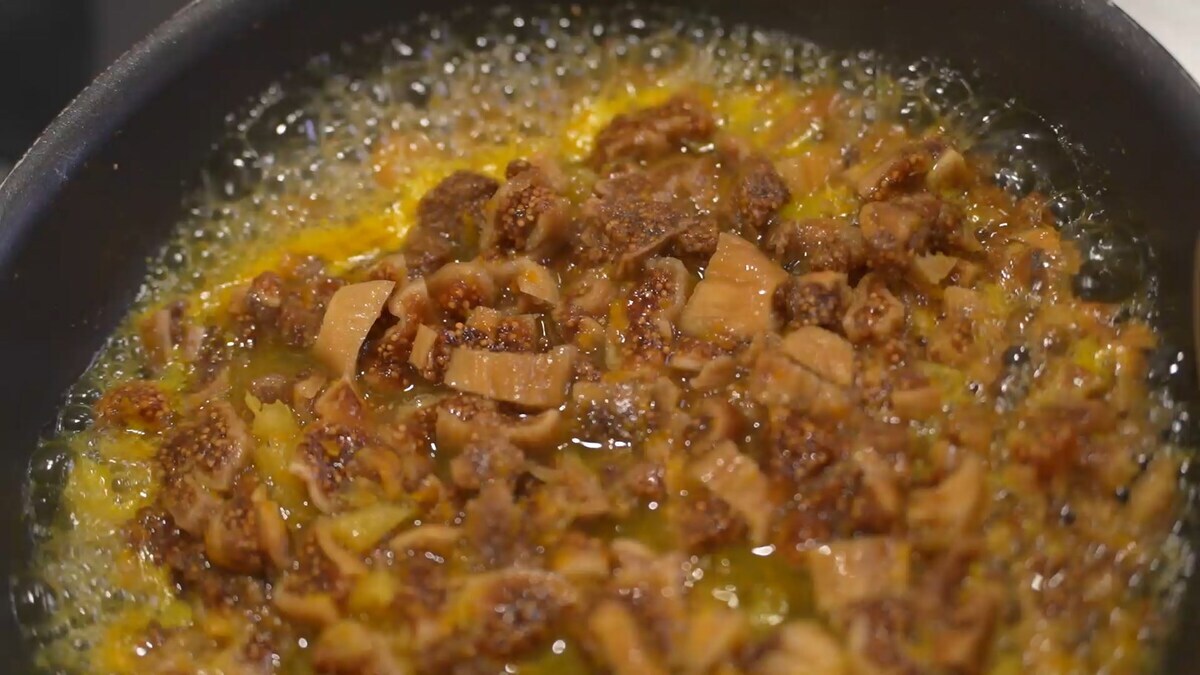 Инжир нарезать небольшими кусочками, выложить в разогретую сковороду, добавить сок и цедру апельсина и томить на среднем огне, пока он не станет мягким, затем размять лопаткой.