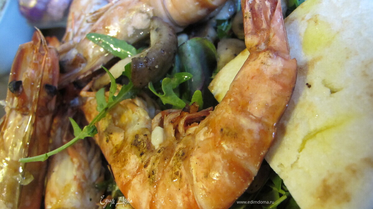 Тигровые креветки с табаско, лимоном и чесноком на листовой подушке с теплой питой