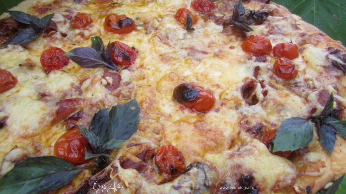 Пицца с вяленым мясом и запеченными помидорами.