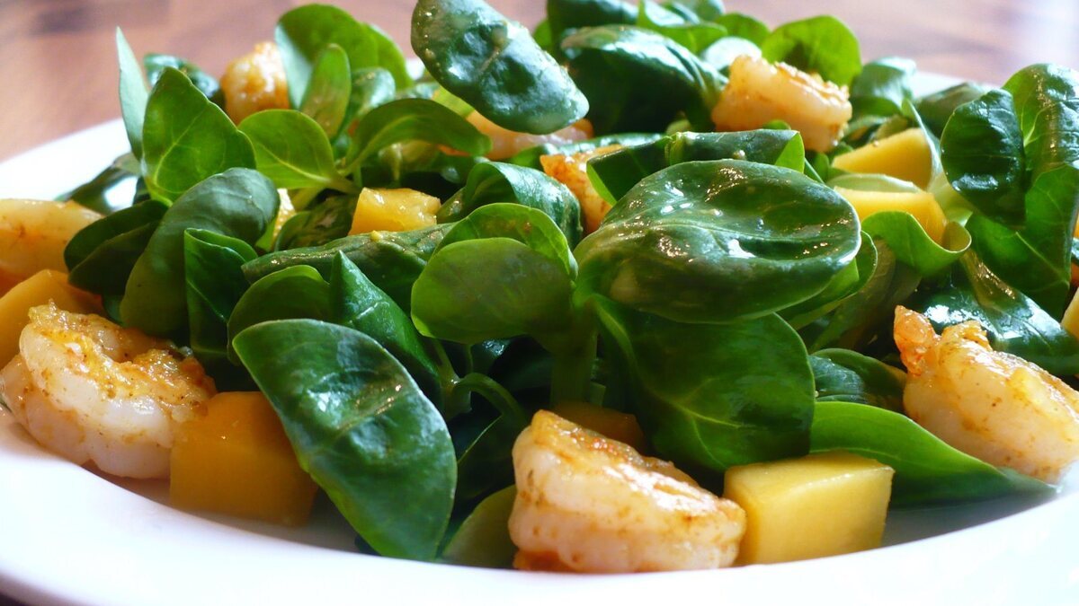 Кисло-сладкие креветки-карри на подушке из полевого салата с манго